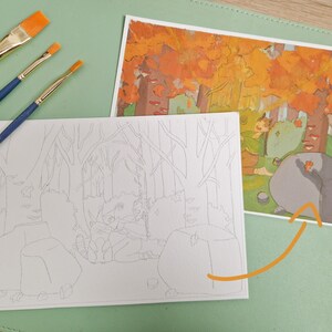 May include: Three paintbrushes with blue handles and orange bristles are next to two illustrations. One is a color-in-the-lines drawing of a forest scene with a raccoon. The other is a completed painting of the same scene with cartoon characters.