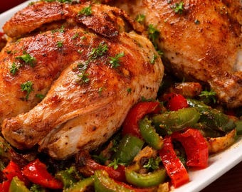 May include: A plate of roasted chicken with golden-brown skin, garnished with fresh herbs. The dish is served with a colorful medley of sautéed red and green bell peppers, creating a vibrant and appetizing meal.