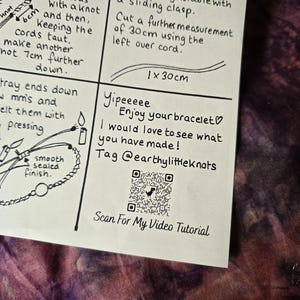 May include: A white instructional card with black ink illustrations and text detailing bracelet making steps. It includes a QR code labeled Scan For My Video Tutorial, a section for a 30 cm cord measurement, and the text Yipeeeee Enjoy your bracelet.