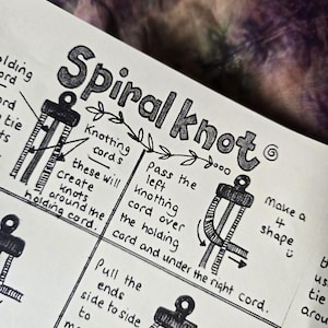 May include: A black and white instructional diagram on paper titled Spiral knot. It features hand-drawn illustrations of cords being tied, with text explaining steps like passing the left knotting cord over the holding cord and making a 4 shape.