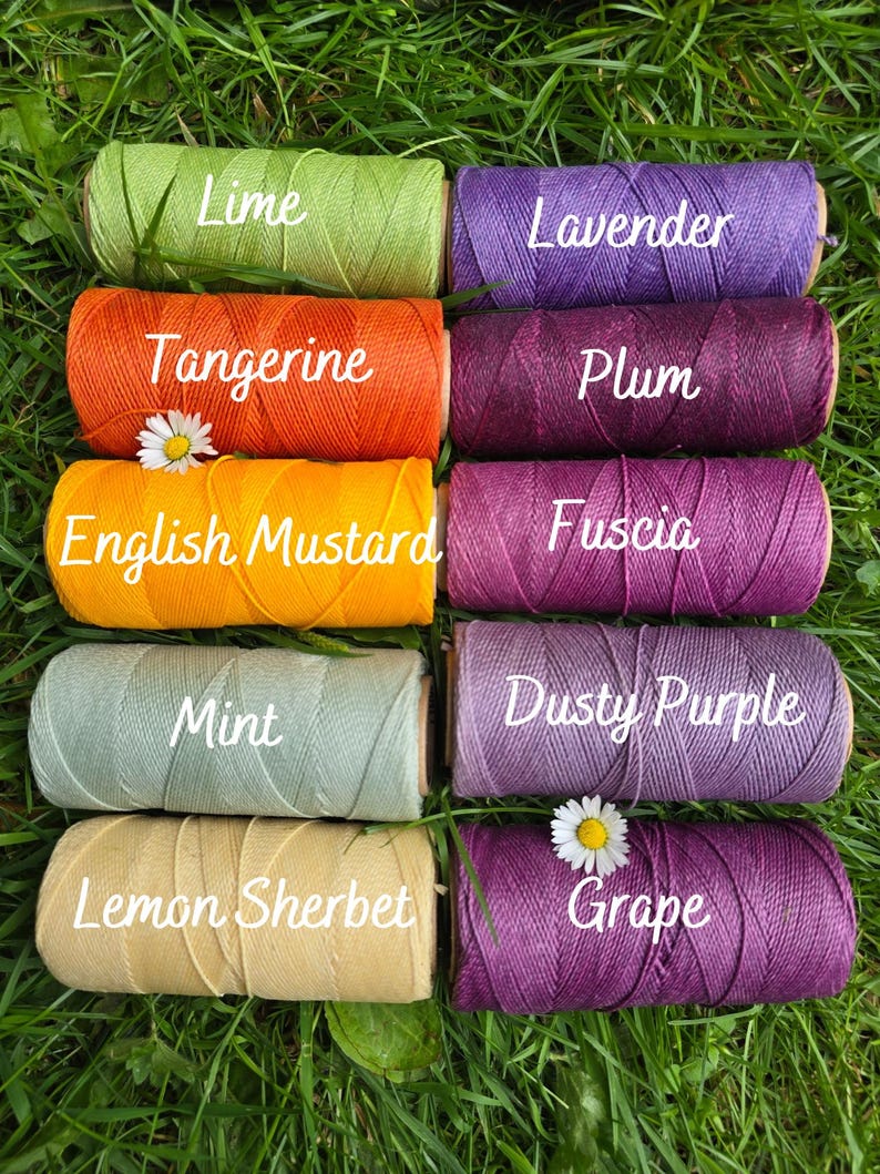 May include: Ten cylindrical spools of colored twine arranged in two columns. The left column features Lime, Tangerine, English Mustard, Mint, and Lemon Sherbet. The right column features Lavender, Plum, Fuscia, Dusty Purple, and Grape.