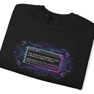 Könnte beinhalten: Schwarzes Sweatshirt mit einem Neon-Grafikdesign. Das Design enthält den Text "SYSTEM ERROR" und eine Meldung, dass das Karma neu gestartet werden muss. Das Design zeigt eine Leiterplatte, Augen und Schaltflächen mit Sätzen wie "REBOOT SPIRIT".
