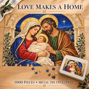 Op de afbeelding: Een 1000-stukjes legpuzzel met een mozaïek-stijl illustratie van de Heilige Familie met de tekst LOVE MAKES A HOME. De set bevat een metalen blik met dezelfde afbeelding op het deksel en enkele losse puzzelstukjes op een houten ondergrond.