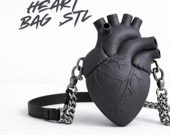 May include: A black heart-shaped bag with a chain strap and a leather strap. The bag has a detailed anatomical design and the text "HEART BAG STL" in a handwritten font.