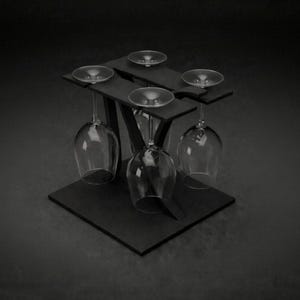 May include: A contemporary black wine glass holder with a geometric design. It features four wine glasses, three of which are suspended upside down. The holder is constructed from dark wood or a similar material.