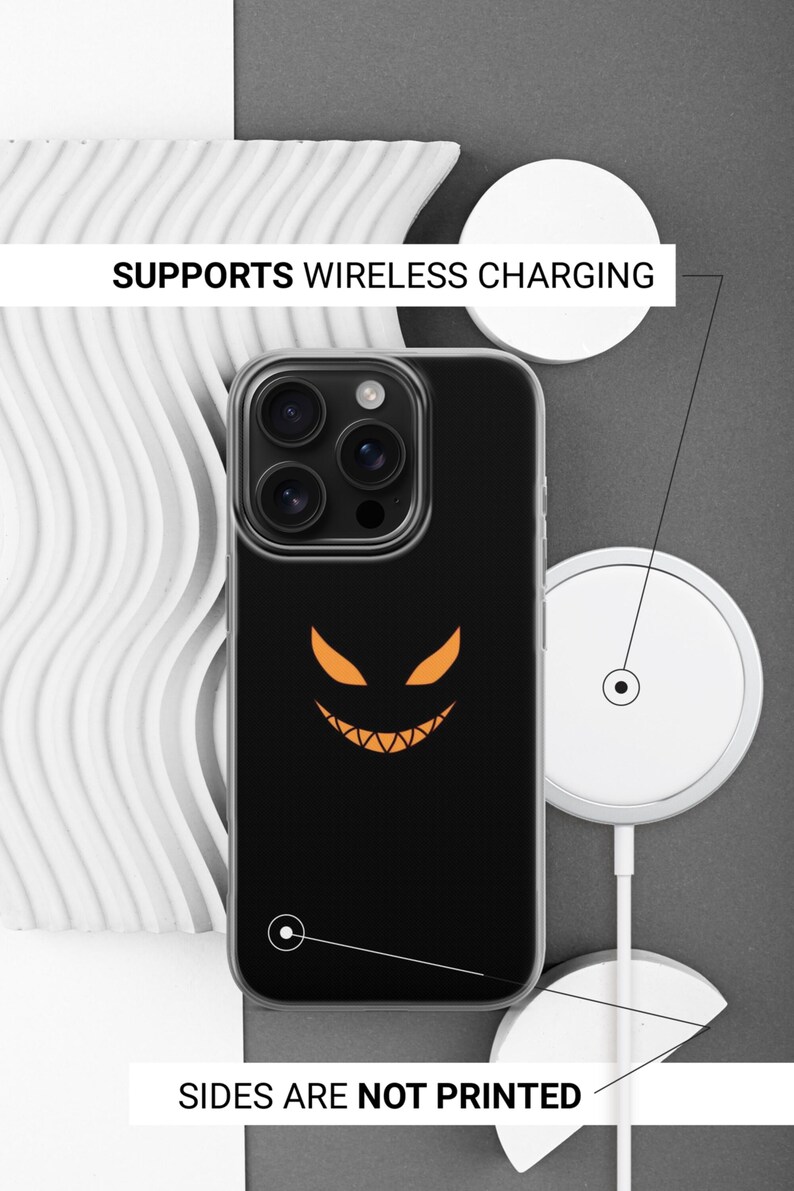 K&ouml;nnte beinhalten: Schwarze Handyh&uuml;lle mit transparentem Rand, mit einem orangefarbenen K&uuml;rbisgesicht-Design. Die H&uuml;lle unterst&uuml;tzt kabelloses Laden. Der Text auf dem Bild lautet: "SUPPORTS WIRELESS CHARGING" und "SIDES ARE NOT PRINTED".