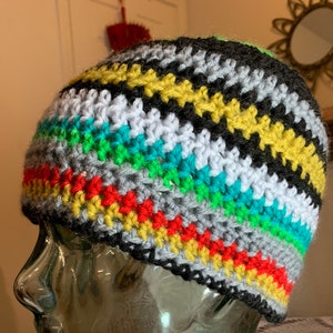 May include: A colorful crocheted beanie hat with stripes of black, gray, white, red, yellow, green, and turquoise.