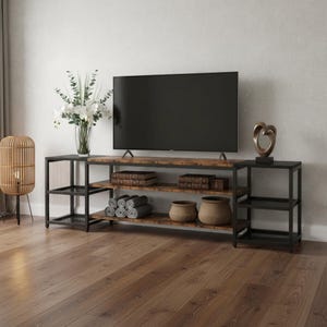 May include: A rustic-style TV stand with a black metal frame and distressed wood shelves. The stand features multiple shelves for storage, holding books, baskets, and rolled towels. A large flat-screen TV sits atop the stand, with decorative items on either side.
