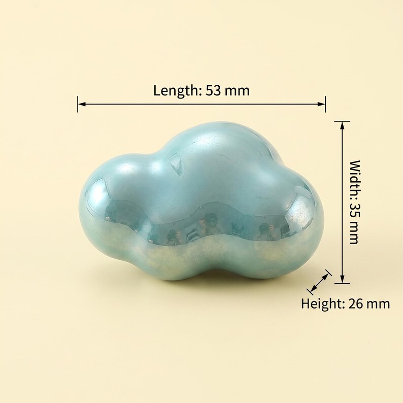 May include: A smooth, iridescent light blue cloud-shaped object with a glossy finish. Technical annotations indicate a length of 53 mm, a width of 35 mm, and a height of 26 mm. The object has a rounded, organic form with multiple bulbous sections.