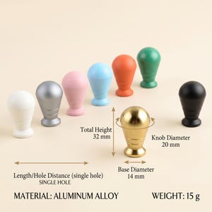Op de afbeelding: Een collectie van enkelgats knoppen van aluminiumlegering in wit, zilver, roze, blauw, oranje, groen, goud en zwart. De gouden knop heeft labels die een totale hoogte van 32 mm, een knopdiameter van 20 mm en een basisdiameter van 14 mm aangeven.