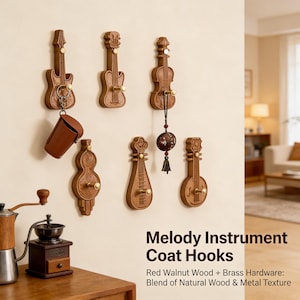 Könnte beinhalten: Eine Sammlung von Holzhaken in Form von Musikinstrumenten, darunter Gitarren und Geigen, die an einer beigefarbenen Wand befestigt sind. Die Haken sind aus rotem Walnussholz mit Messingbeschlägen gefertigt. Eine braune Ledertasche hängt an einem der Haken. Der Text "Melody Instrument Coat Hooks" ist sichtbar.