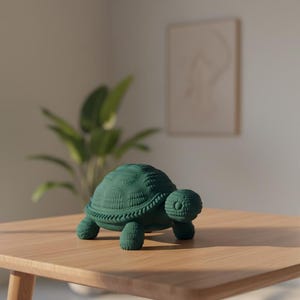 May include: A dark green turtle figurine with a textured shell and detailed features. The decorative turtle is placed on a light brown wooden table. The figurine has four stubby legs and a small head.