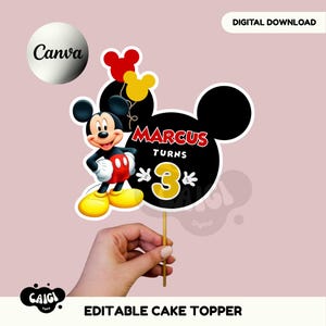 Pode incluir: Um topo de bolo com a silhueta preta da cabeça do Mickey Mouse e o texto Marcus Turns 3 em vermelho e amarelo. Um desenho do Mickey Mouse está à esquerda com calções vermelhos e sapatos amarelos. Dois pequenos balões estão acima.