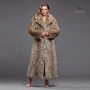 Könnte beinhalten: Ein langer Mantel mit Leopardenmuster, breitem Kragen und langen Ärmeln. Der Mantel hat ein klassisches Design mit Knopfverschluss und fließender Silhouette. Der Kunstfellmantel ist in Braun- und Beigetönen gehalten.