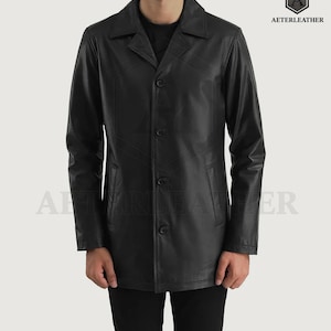 以下が含まれることがあります： ボタン留めの襟付き黒革コート。コートは長袖で、前面に2つのポケットが付いています。「AETERLEATHER」のブランド名が右上に見えます。