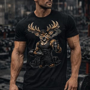 Può includere: T-shirt nera con un cervo dei cartoni animati con le corna, che indossa un berretto e tiene un manubrio e un bicchiere shaker. La scritta "SHAKE" è visibile sulla tazza. L'immagine è ambientata in una palestra.