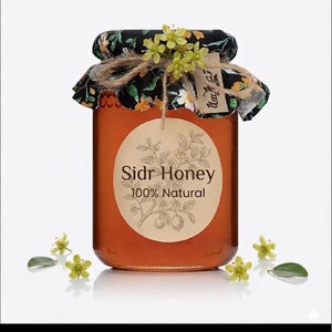 May include: A glass jar filled with amber-colored honey, labeled "Sidr Honey 100% Natural." The jar is adorned with a floral fabric lid, twine, and small yellow flowers. A round label with botanical illustrations is centered on the jar.