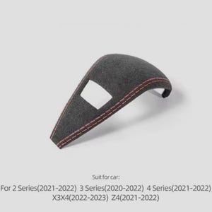 May include: A dark grey car interior trim piece with red stitching. The trim has a rectangular cutout and is designed for specific car models, including the 2, 3, 4 Series, X3X4, and Z4.