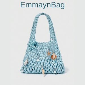 May include: A light blue macrame handbag with a woven handle. The bag is decorated with seashells, starfish, and pearls. The text "EmmaynBag" is at the top of the image.