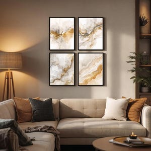 May include: Four framed abstract art prints with gold, brown, and white watercolor designs hang above a beige sectional sofa. The living room features a round coffee table, a floor lamp, and decorative pillows.