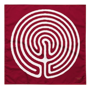 May include: A white labyrinth design on a burgundy red square fabric. The labyrinth is a circular pattern with a central point and multiple concentric circles.