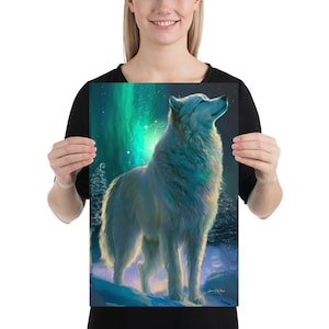 May include: A print depicting a white wolf in a snowy scene, looking up towards a vibrant aurora borealis. The artwork showcases a green and blue aurora in the background, with a soft, radiant light highlighting the wolf.