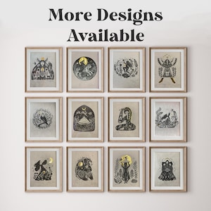 May include: A collection of framed art prints with a mystical theme. Each print features black and gold illustrations of celestial and nature-inspired designs, including moons, animals, and figures. The text "More Designs Available" is at the top.