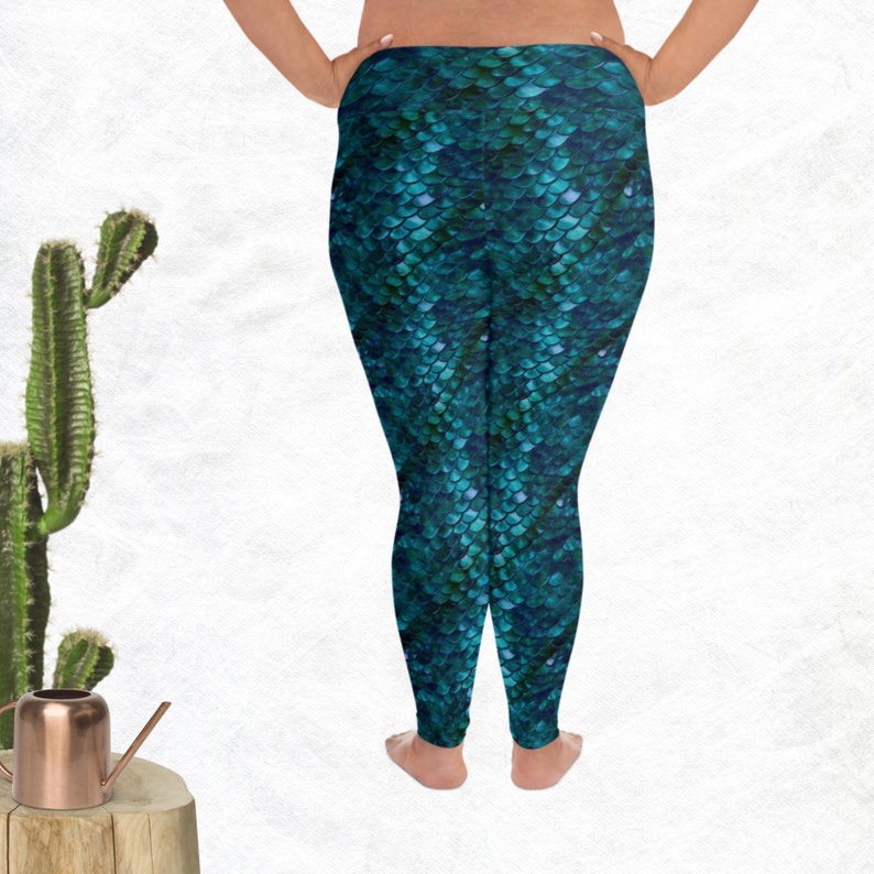 May include: Teal blue leggings with a mermaid scale pattern. The leggings are made of a stretchy, comfortable fabric and are perfect for yoga, running, or everyday wear.