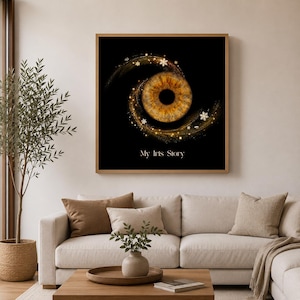 Könnte beinhalten: Ein quadratischer Wandkunstdruck mit einer detaillierten braunen menschlichen Iris auf schwarzem Hintergrund, umgeben von einem wirbelnden goldenen Lichteffekt mit kleinen Schneeflockensymbolen und dem Text My Iris Story in weißer Schrift.
