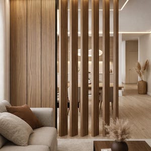 May include: Interior design featuring a modern living room with wooden accents. A light-colored sofa with brown pillows sits in front of a wooden wall and a slatted wooden room divider. A coffee table with books and a vase is in the foreground.