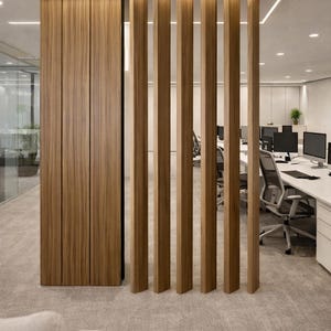 May include: Interior office space with a wooden slat divider. The divider is made of vertical wooden beams, and a wooden panel. The office has white desks, chairs, and computers. The floor is covered in a light gray carpet.