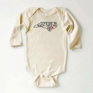 Body para bebé con el mensaje "Alguien en Carolina del Norte me ama", camiseta adorable para bebé, regalos para baby shower, camiseta para bebé con el mensaje "Amado", body para bebé con el estado, camiseta natural para bebé. imagen 5
