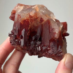 May include: A white ceramic mug with a black handle and the text "But First, Coffee" in a bold, black font. The mug is set against a neutral background, highlighting its simple design.