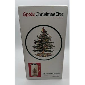 May include: A white box with the text "Spode Christmas Tree" and a circular illustration of a decorated Christmas tree. Below, a picture of a thermal carafe with a Christmas tree design. The text "Thermal Carafe" is also present.