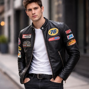 以下が含まれることがあります： 「76」パッチとChampionパッチを含む、複数のパッチが付いた黒い革のジャケット。 ジャケットはジッパー開閉と黒いベルトが付いています。 白いTシャツと黒いジーンズを着用しています。