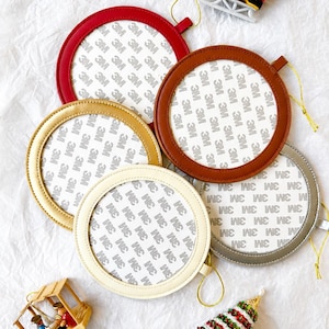 May include: Five circular ornaments in red, brown, gold, cream, and silver with 3M adhesive backing. Each ornament features a gold hanging string. Included are two small decorative Christmas ornaments: a red ice skate and a green tree.