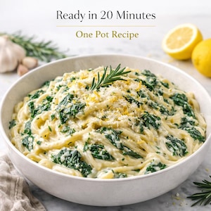 May include: A white bowl filled with creamy pasta, spinach, and grated cheese. Garnished with a sprig of rosemary and lemon zest. The text "Ready in 20 Minutes One Pot Recipe" is at the top.