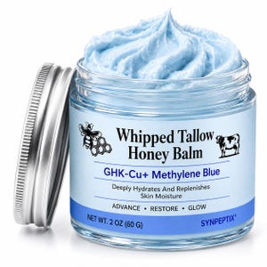 May include: A clear glass jar filled with light blue whipped tallow honey balm, topped with a silver lid. The label features a bee, a cow, and the text: Whipped Tallow Honey Balm, GHK-Cu+ Methylene Blue, Deeply Hydrates And Replenishes Skin Moisture, ADVANCE • RESTORE • GLOW, NET WT. 2 OZ (60 G), SYNPEPTIX.