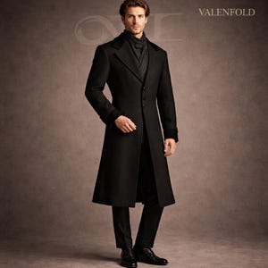 May include: A black, long coat with a notched collar and a three-button closure. The coat has a tailored fit and is worn with a gray scarf and black pants. The brand name "VALENFOLD" is visible in the upper right corner.