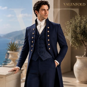 Op de afbeelding: Een marineblauwe lange jas met gouden knopen, een donkerblauw vest met patroon en een witte cravat. Het kledingstuk heeft een hoge kraag en een gestructureerde pasvorm. De tekst VALENFOLD is zichtbaar in de rechterbovenhoek van de afbeelding.
