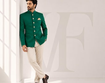 Puede incluir: Una chaqueta verde con botones dorados y un pañuelo de bolsillo a juego, combinada con pantalones beige y zapatos de vestir marrones. La chaqueta tiene cuello mandarín. La palabra "VALENFOLD" está en oro en la esquina superior derecha.
