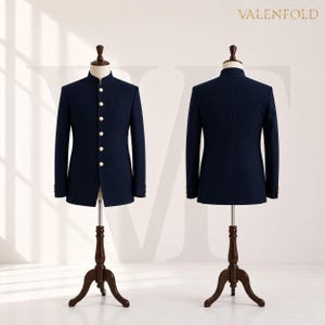 Puede incluir: Chaqueta azul marino con cuello mao y botones dorados, expuesta sobre un maniqu&iacute; de madera. La chaqueta se muestra de frente y de espalda. La marca "VALENFOLD" est&aacute; impresa en la parte superior. Corte entallado.