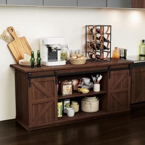 May include: A white ceramic mug with a black handle and the text "But First, Coffee" in a black, bold font. The mug is on a white surface.