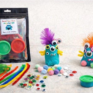 May include: A Build Your Own Monster Kit with craft supplies. The kit includes colourful feathers, pipe cleaners, googly eyes, pom-poms, and two pots of play dough. Two finished monster creations are also shown.