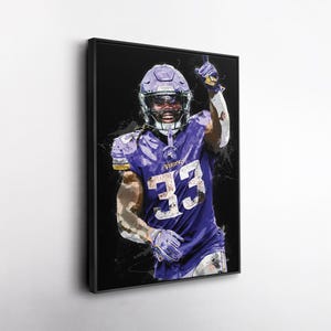 May include: A framed art print of a football player in a purple uniform with the number 33. The player is wearing a helmet and raising their arm. The artwork has a watercolor effect against a black background.