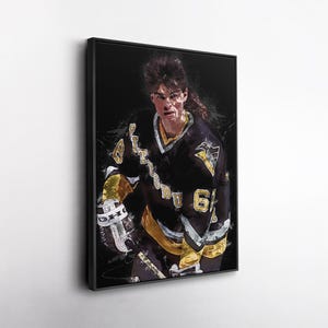May include: Framed art print depicting a hockey player in a black and gold Pittsburgh Penguins jersey. The jersey displays the number 66. The artwork has a painterly effect with a dark background.