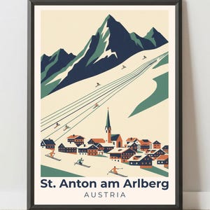 May include: Framed vintage travel poster of St. Anton am Arlberg, Austria. The artwork features a stylized illustration of a mountain range with skiers, a village, and the text "St. Anton am Arlberg AUSTRIA" in a black frame.