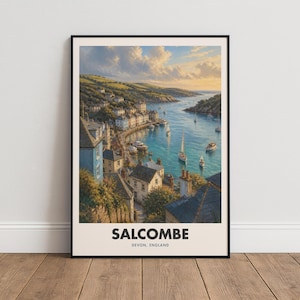 Peut inclure: Une affiche encadrée représentant un paysage côtier de Salcombe, Devon, Angleterre. L'image montre un port avec des bateaux sur une eau bleue, entouré de maisons à flanc de colline et de falaises vertes sous un ciel au coucher du soleil. Texte : SALCOMBE DEVON, ENGLAND.