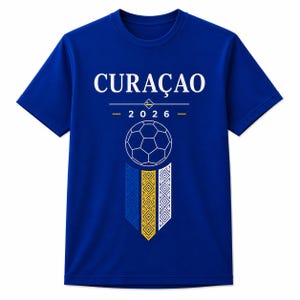 May include: A royal blue short-sleeve t-shirt featuring the white text CURAÇAO above the year 2026. Below the year is a white line-art soccer ball graphic centered above three vertical rectangular banners in blue, yellow, and white with patterns.