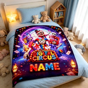 May include: A rectangular fleece blanket featuring a colorful graphic print of The Amazing Digital Circus characters, including a jester, a rabbit, and a ringmaster. The design includes the text The Amazing Digital Circus and a customizable NAME area.